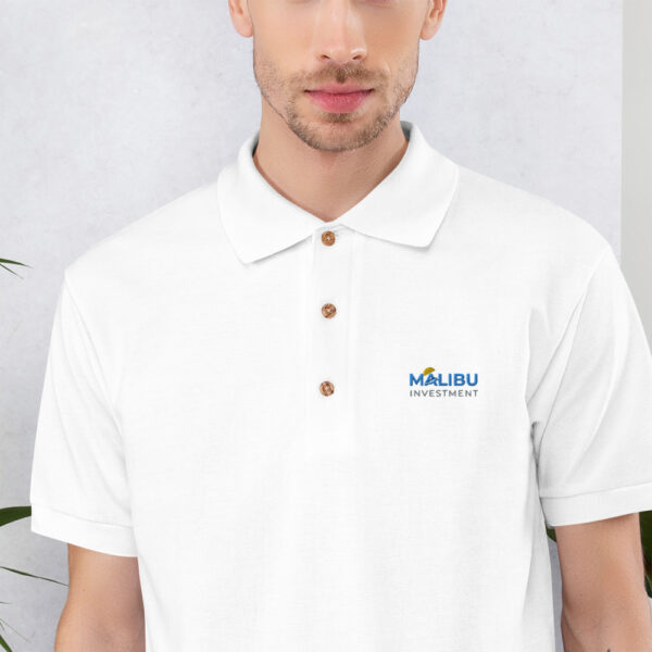 White polo shirt with Malibu Investment logo.